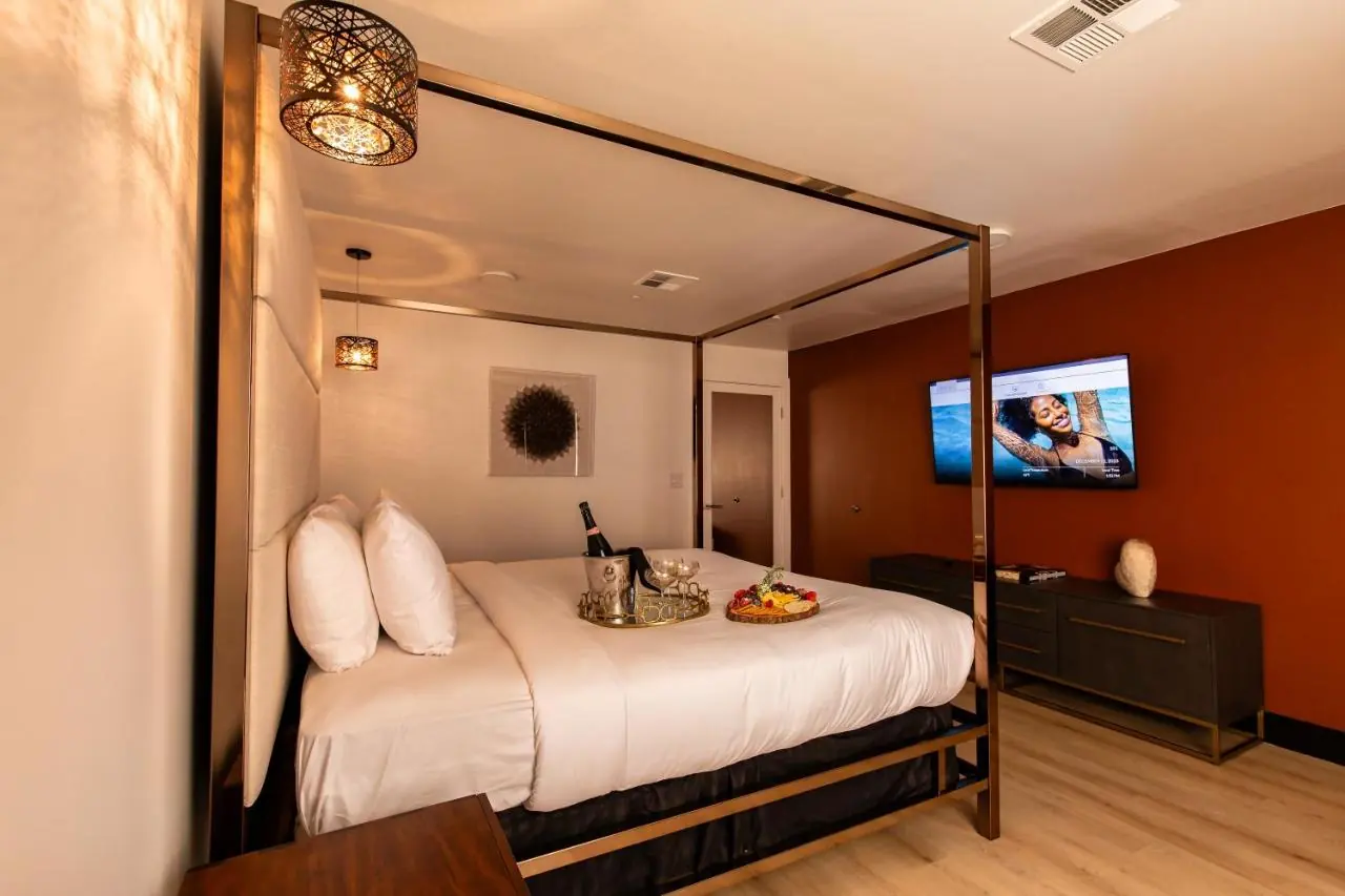 Finished hotel room furnished by New Wings with custom bed, casegoods, lighting and drapery